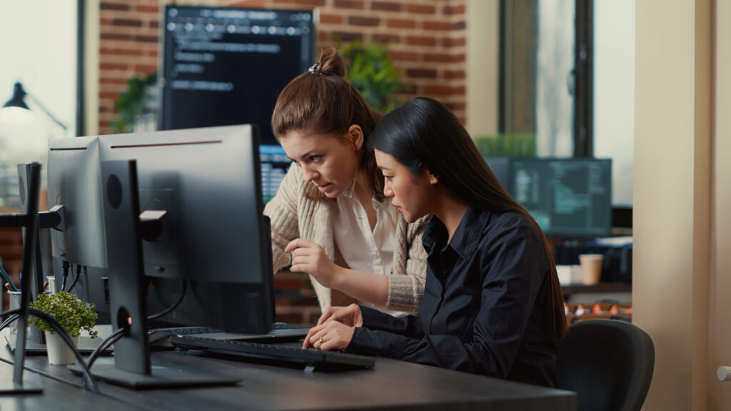 Team Coworkers Comparing Source Codes Running Laptop Screen Computer Monitor It Development Office Software Developers Collaborating Data Coding Group Project While Sitting Desk 1024x576